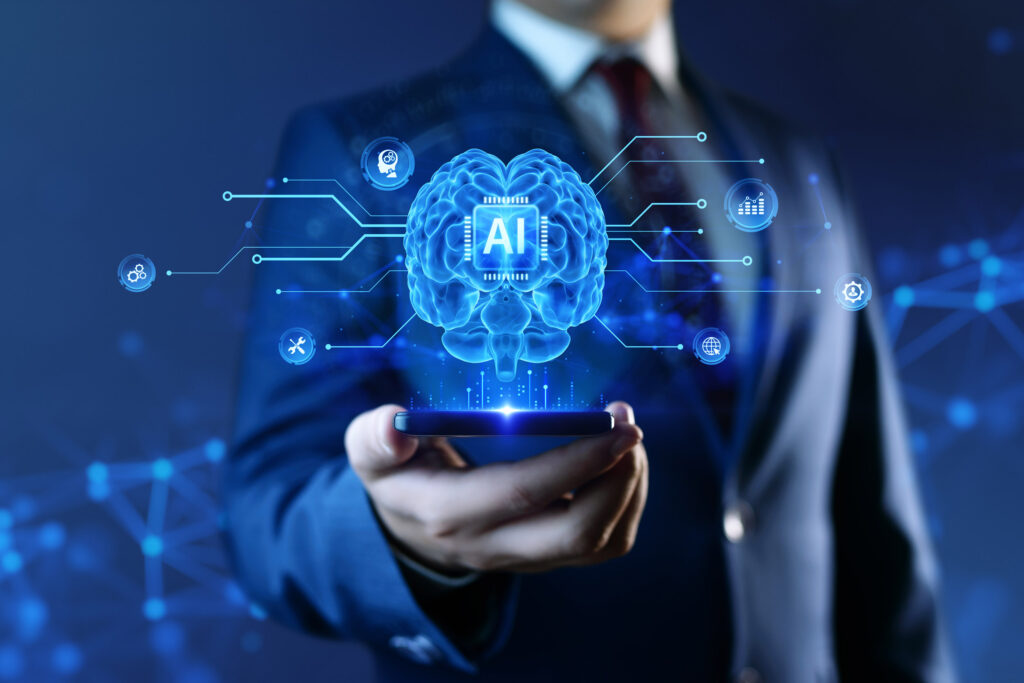 AI - Artificial Intelligence Concept. A businessman holds a smartphone with a hologram of a human brain and HUD of deep machine learning, automation, and Neural Networks